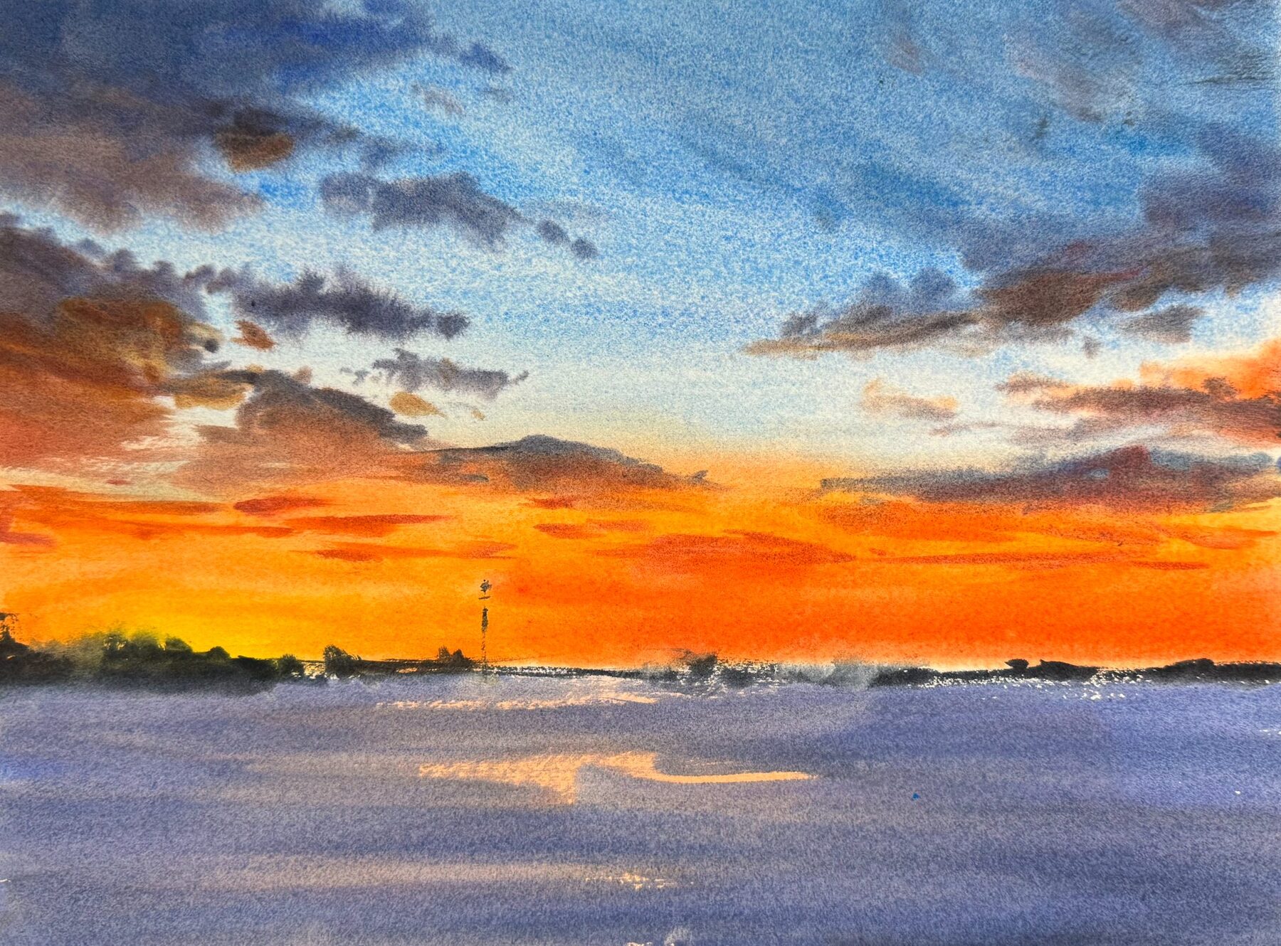 Orange vintersol över fruset vatten och låg horisont.